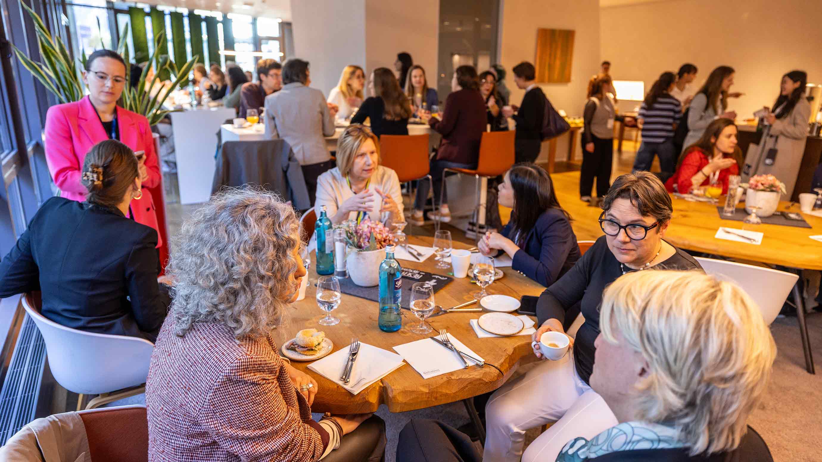 Trade fair attendees sitting at a table, talking and having coffee in a lounge-like setting.