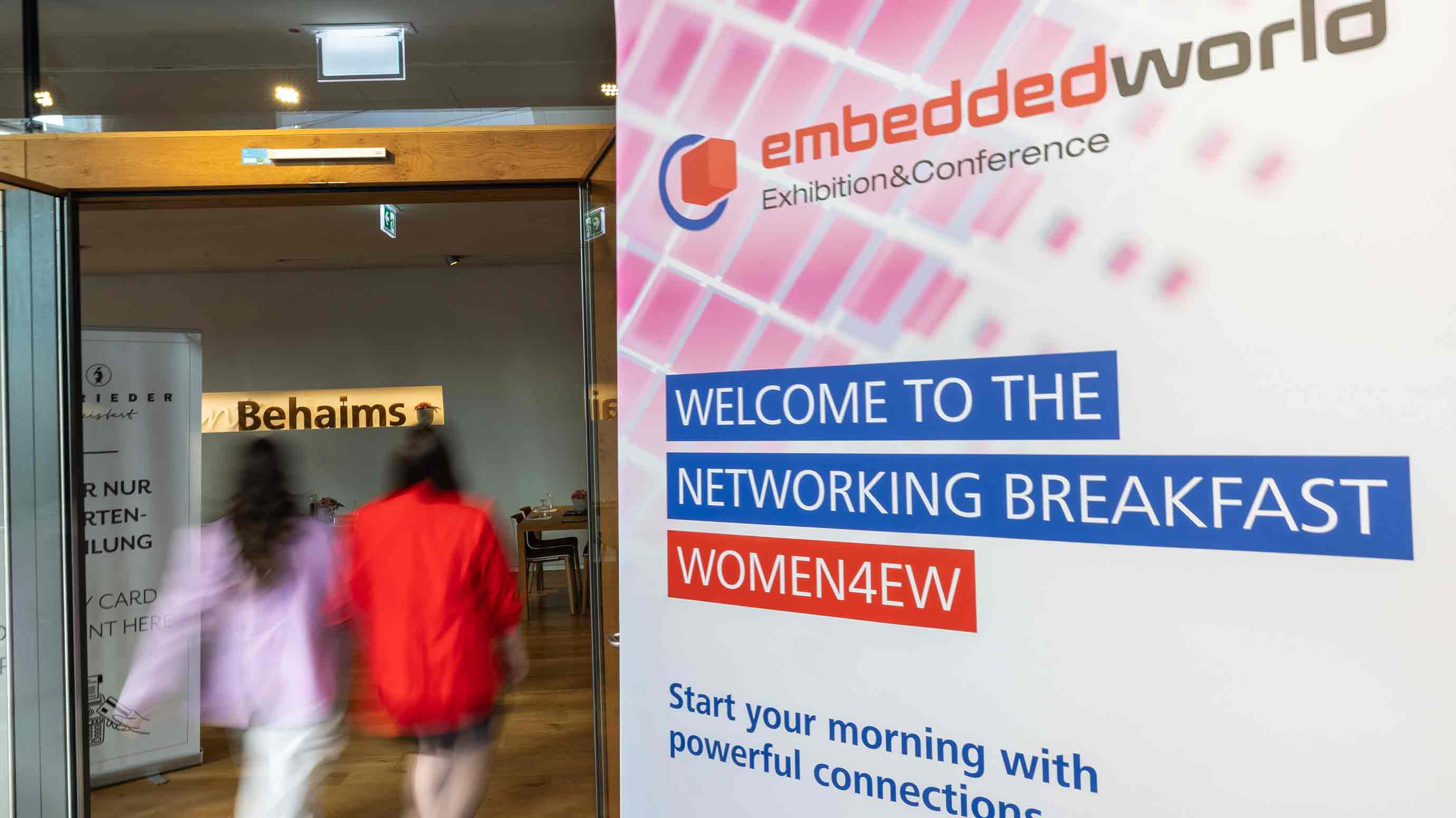 Event sign reading “Networking Breakfast WOMEN4EW” at the entrance