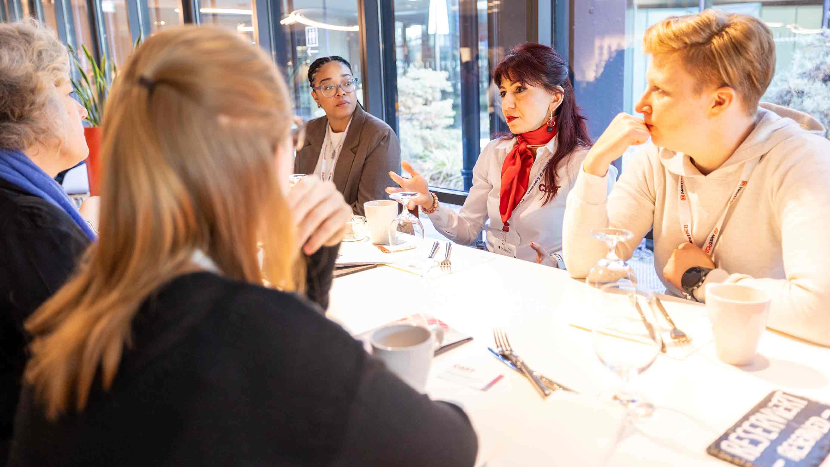 Gruppe diskutiert an einem Tisch in einem hellen Raum