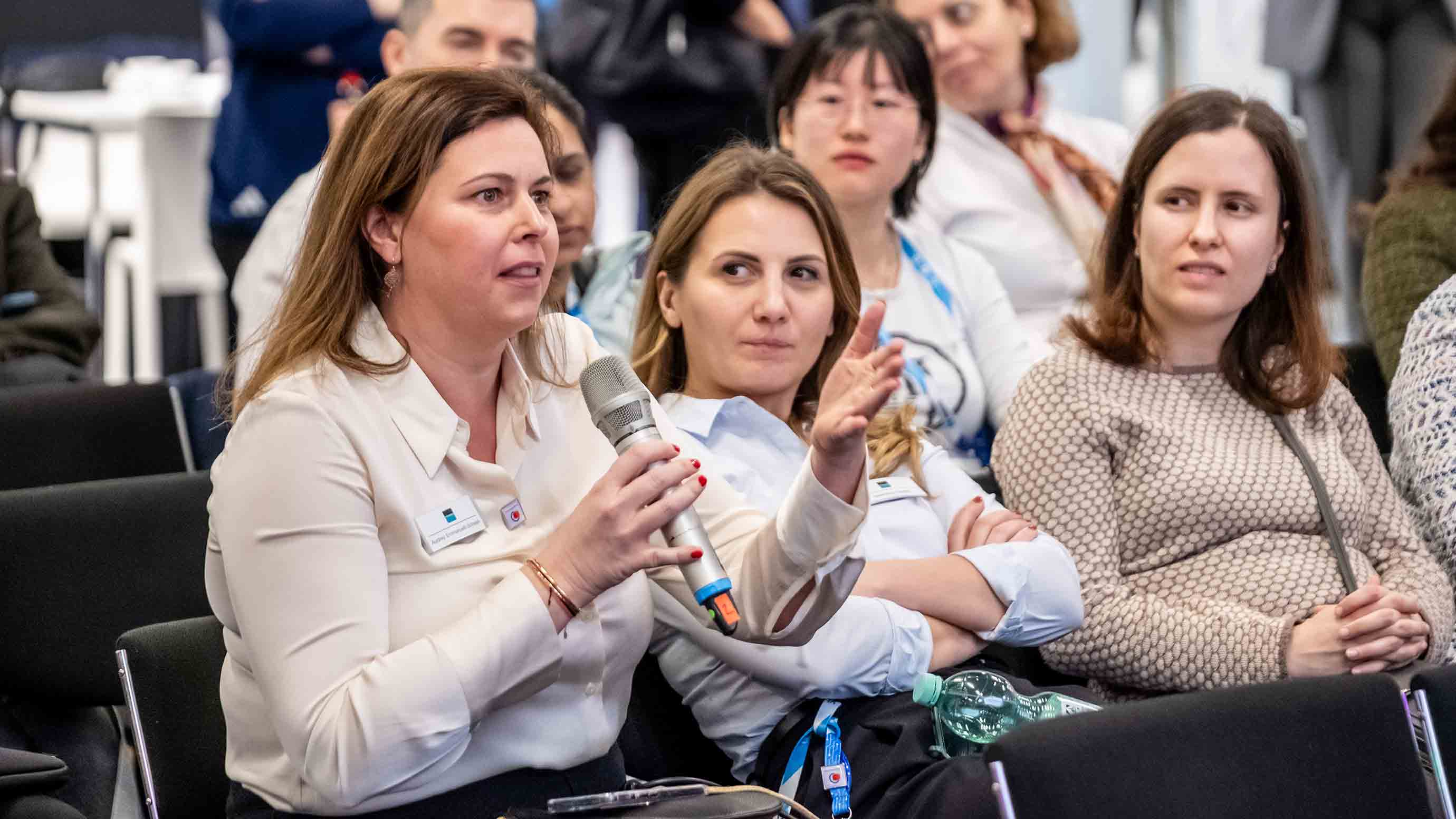 A woman from an audience is asking the speaker a question