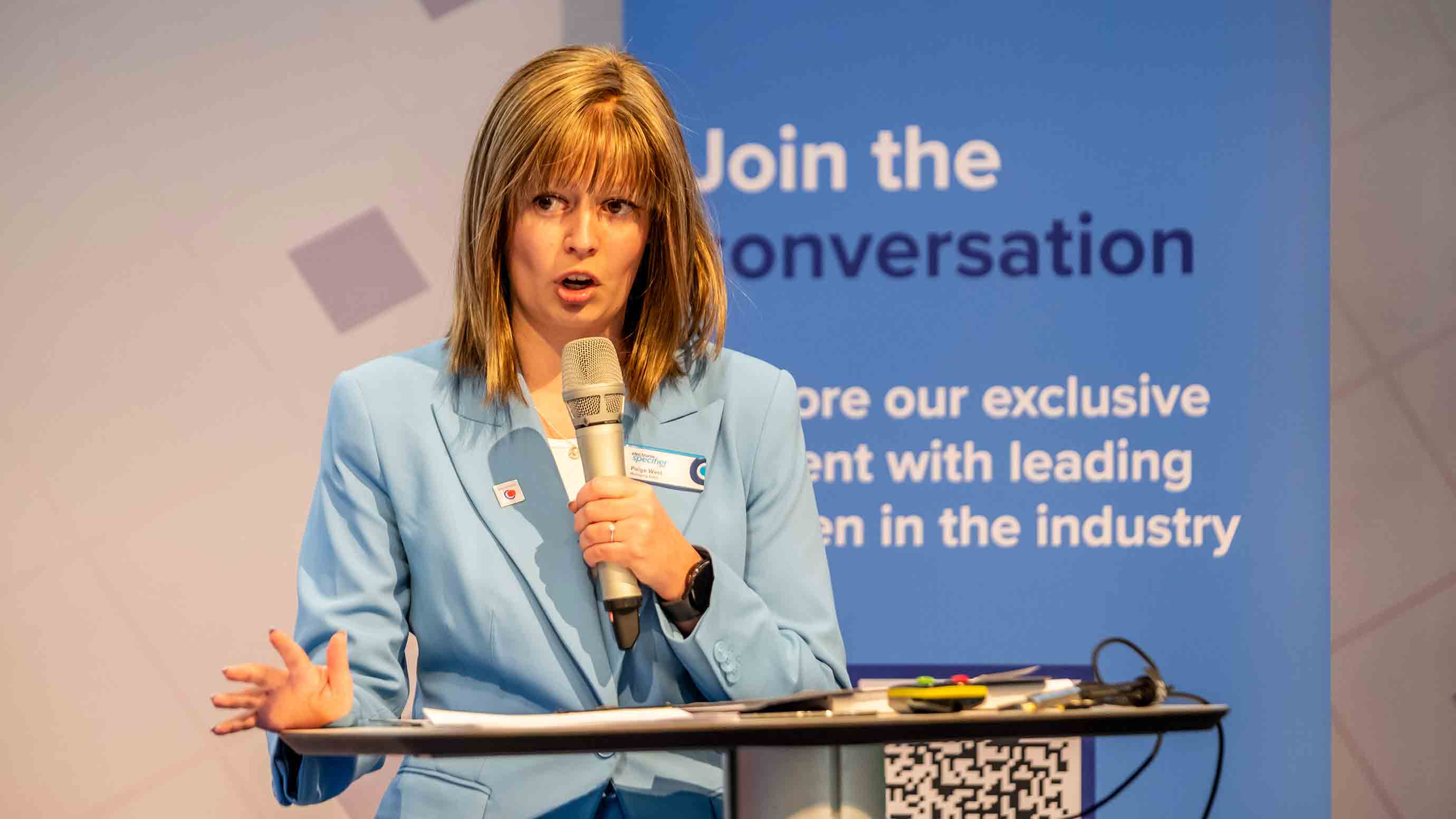 Female speaker on stage presenting